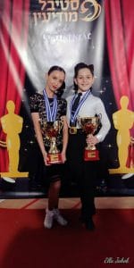 זוג רקדני ריקודים סלוניים ולטיניים עם גביעים של מנצחים בתחרות ריקודים